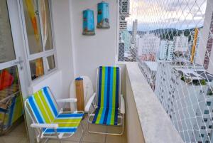 2 sillas sentadas en un balcón junto a una ventana en Apto no centro, com ótima localização, en Balneário Camboriú