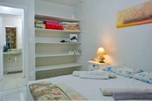 1 dormitorio con cama, lámpara y estanterías en Apto no centro, com ótima localização, en Balneário Camboriú