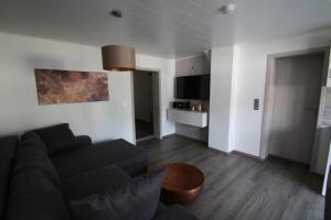 a living room with a black couch and a table at Milonia in Bernkastel-Kues