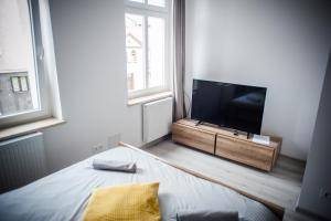 a bedroom with a tv and a bed in a room at Ahoj Apartments in Ustka