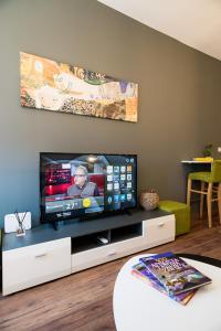 a living room with a flat screen tv on a entertainment center at Homesweethome Apartments in Thessaloniki