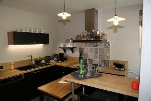 uma cozinha com uma mesa com garrafas e copos em Villa Victoire em Aulos