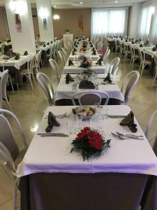 a large banquet hall with white tables and white chairs at Bikini Hotel in Vieste