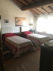 a bedroom with two beds with red and white blankets at La Streghina Paolina in Verrua Savoia