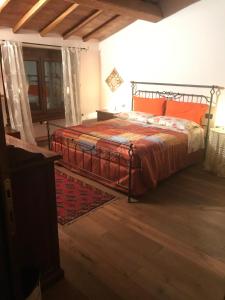 een slaapkamer met een bed met een oranje dekbed bij La Streghina Paolina in Verrua Savoia