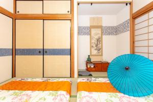 ein Schlafzimmer mit 2 Betten und einem blauen Regenschirm in der Unterkunft City Center House Next to Subway Station in Kyoto