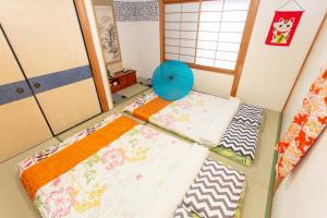 Bett mit einer Decke auf dem Zimmer in der Unterkunft City Center House Next to Subway Station in Kyoto
