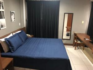 sypialnia z niebieskim łóżkiem i biurkiem w obiekcie Summit Dom Apart Hotel w mieście Lorena