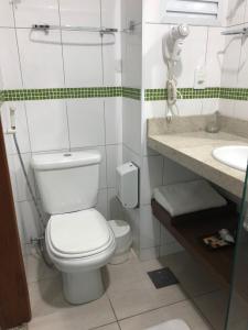 a bathroom with a toilet and a sink at Summit Dom Apart Hotel in Lorena