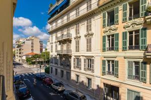 a view of a city street with cars parked in front of a building at Nice Central Art Deco Flat 45 m² in Nice