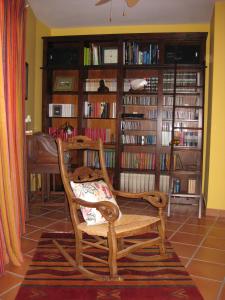 a wooden chair in a room with book shelves at Casa Agua Marina in San José