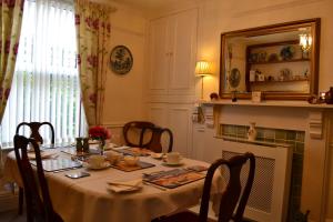 a dining room with a table with chairs and a mirror at Knightsrest in Burnham on Sea