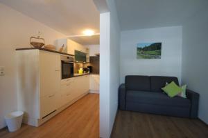 a living room with a couch and a kitchen at Bleierhof Apartment in Kartitsch