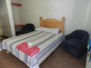 1 dormitorio pequeño con 2 sillas y 1 cama en Consul Suites, en Ciudad Juárez