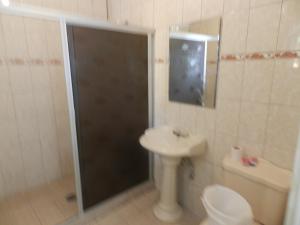 y baño con ducha, lavabo y aseo. en Consul Suites, en Ciudad Juárez
