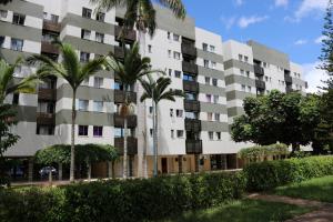 an apartment building with palm trees in front of it at Apartamento Sudoeste in Brasília