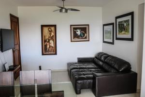 sala de estar con sofá de cuero y TV en Apartamento Sudoeste, en Brasilia
