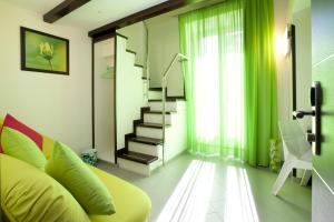 a living room with a green couch and stairs at Sorrento Flats in Sorrento