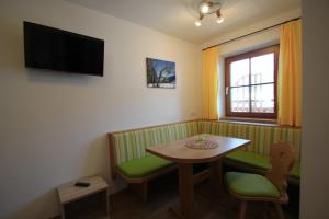 a small room with a table and a television at Bleierhof Apartment in Kartitsch