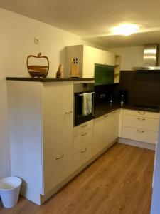 kuchnia z białymi szafkami i koszem na ladzie w obiekcie Bleierhof Apartment w mieście Kartitsch +18 zdjęć