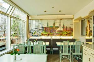 a restaurant with a table and chairs and a stained glass window at Hotel Senator Hamburg in Hamburg