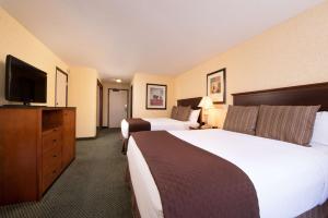 a hotel room with two beds and a flat screen tv at Red Lion Hotel Seattle Airport in SeaTac