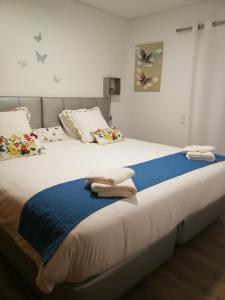 a bedroom with a large bed with two towels on it at cascaischillhouse in Cascais