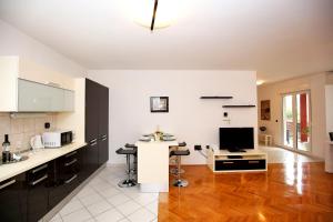 une cuisine avec un comptoir et une table avec une télévision dans l'établissement City Gallery Apartment, à Zadar
