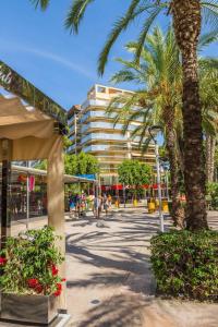 een straat met palmbomen en een gebouw bij apartament de luxe con piscina in Salou