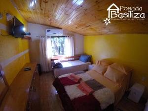 1 dormitorio pequeño con 1 cama y 1 sofá en Posada Basiliza, Encarnación PY, en Encarnación