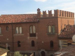 stary ceglany budynek z krzyżem na górze w obiekcie Castello Mellana w mieście Rosignano Monferrato