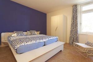 オストゼーバート・カールスハーゲンにあるLotsenstieg 2 Kajuete 01のベッドルーム1室(青い壁の大型ベッド1台、窓付)