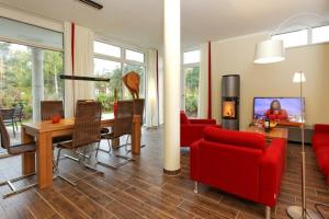 a living room with a red couch and a table at Kapitaensweg 18 in Ostseebad Karlshagen