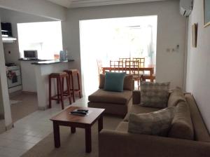 Una sala de estar con dos sofás y una mesa. en Hôtel le Flamboyant, en Abiyán