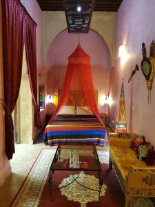 - une chambre avec un lit à baldaquin dans l'établissement Riad Marlinea, à Sale