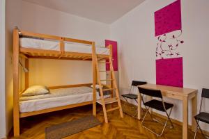1 Schlafzimmer mit Etagenbetten, einem Schreibtisch und einem Tisch in der Unterkunft Centrum House Hostel in Braşov
