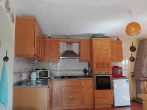 una cucina con mobili in legno e un frigorifero bianco di Quinta do Mineiro-Serra da Estrela a Matança Altre 37 foto