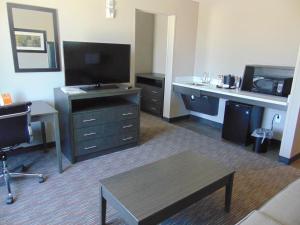 ein Wohnzimmer mit einem Schreibtisch und einem TV in der Unterkunft Wingate by Wyndham Lubbock in Lubbock