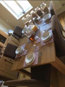 una mesa de madera con platos y utensilios. en Willow Farm Way, en Herne Bay