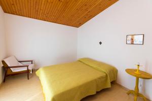 a bedroom with a bed and a chair and a table at Apartments Beba55 m in Primošten