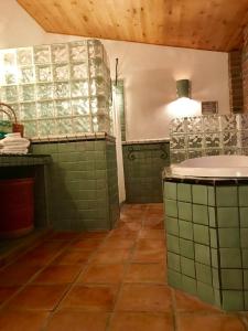 baño con paredes de azulejos verdes y lavabo en Casa Xochitl en La Paz