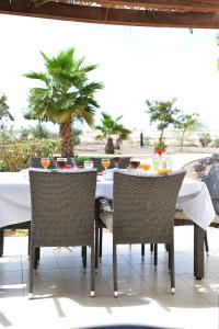 a table with two chairs and a table with drinks on it at Guesthouse Le Châtelain in Santa Maria