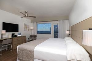 a bedroom with a bed and a desk and a television at Riu Plaza Miami Beach in Miami Beach