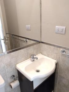 une salle de bains avec un lavabo blanc et un miroir dans l'établissement Apartamento Allegro, à Córdoba