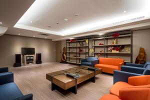 a living room with orange and blue chairs and a coffee table at Full Kind Hotel in Hualien City