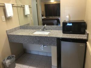 a bathroom with a sink and a microwave at Travelers inn in Bethania Station