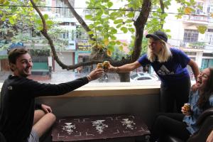 a woman giving a man a glass of beer at Ha Giang 1 Hostel and Loop Tour in Ha Giang