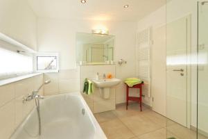 a bathroom with a white tub and a sink at Lotsenstieg 15 in Ostseebad Karlshagen