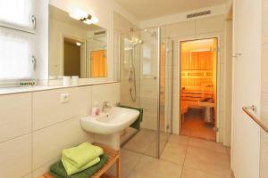 La salle de bains blanche est pourvue d'un lavabo et d'une douche. dans l'établissement Lotsenstieg 15, à Karlshagen