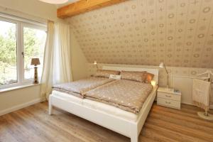 a bedroom with a white bed and a window at Pier 8 in Ostseebad Karlshagen